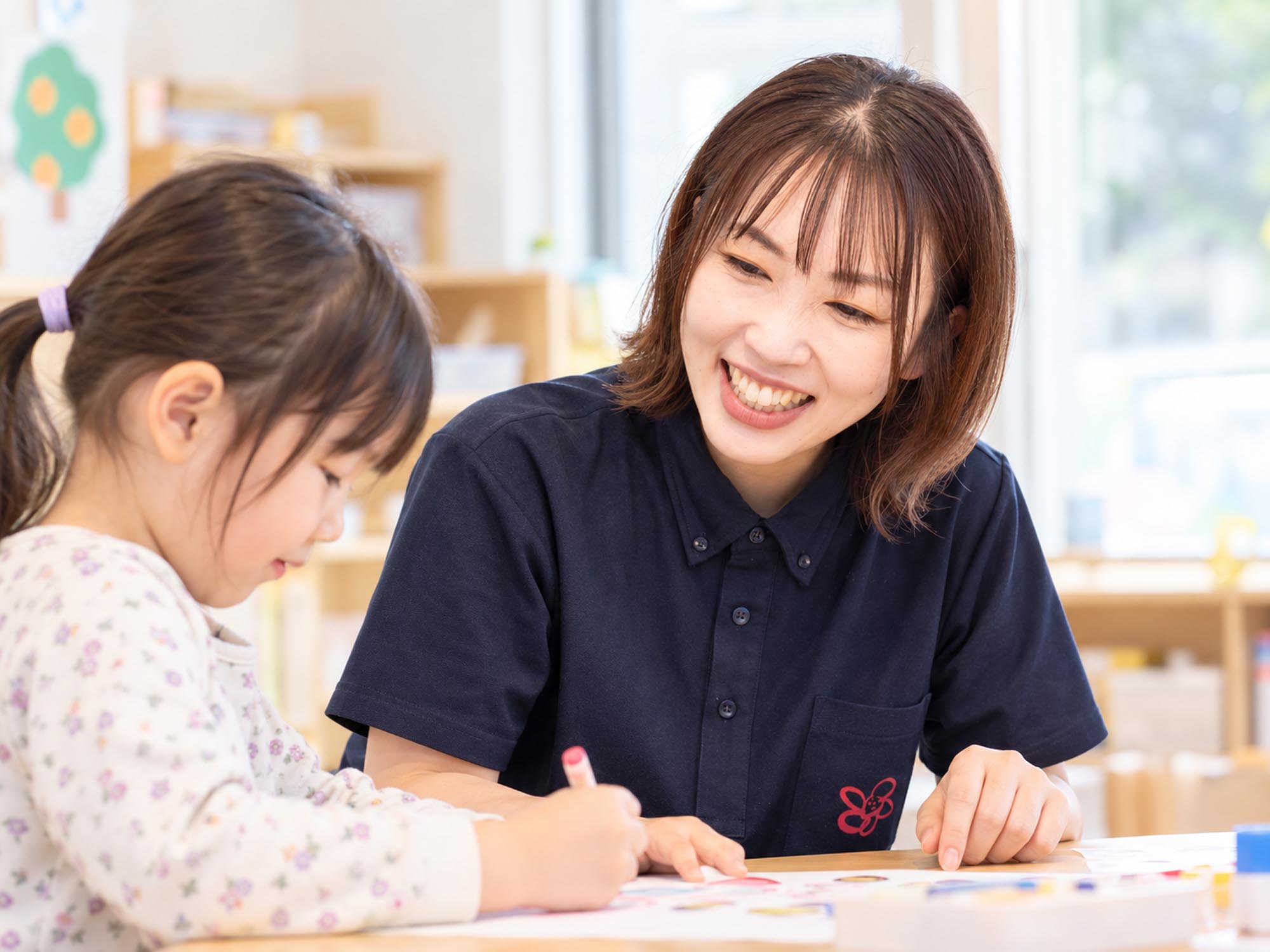 子どもの活動に寄り添いながら見つめるスタッフ