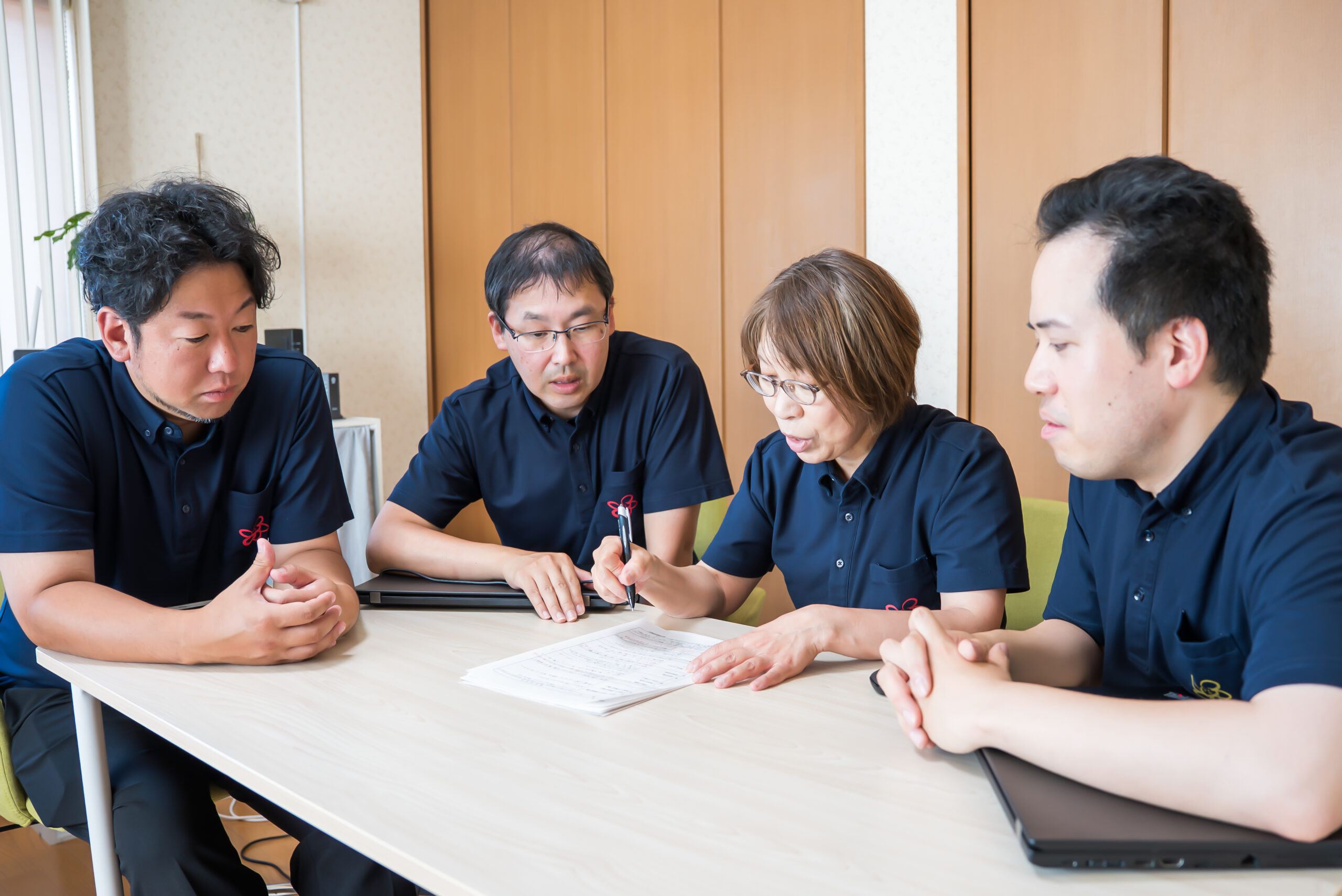 資料を囲んで話し合う、ぽっけりんくの4人のスタッフ