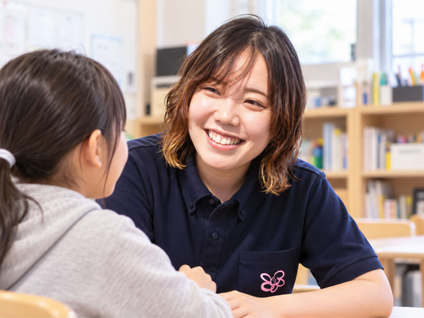 子どもの話に笑顔で耳を傾けるぽっけりんくのスタッフ