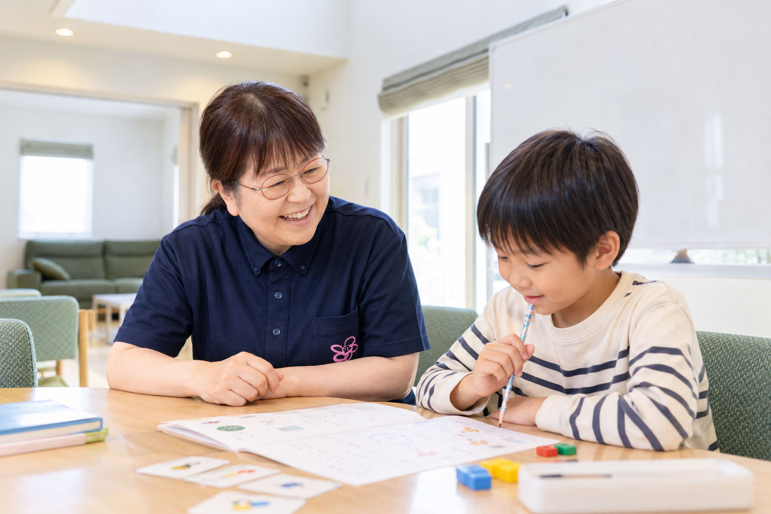 子どもと一緒に学習や課題を考えるスタッフ