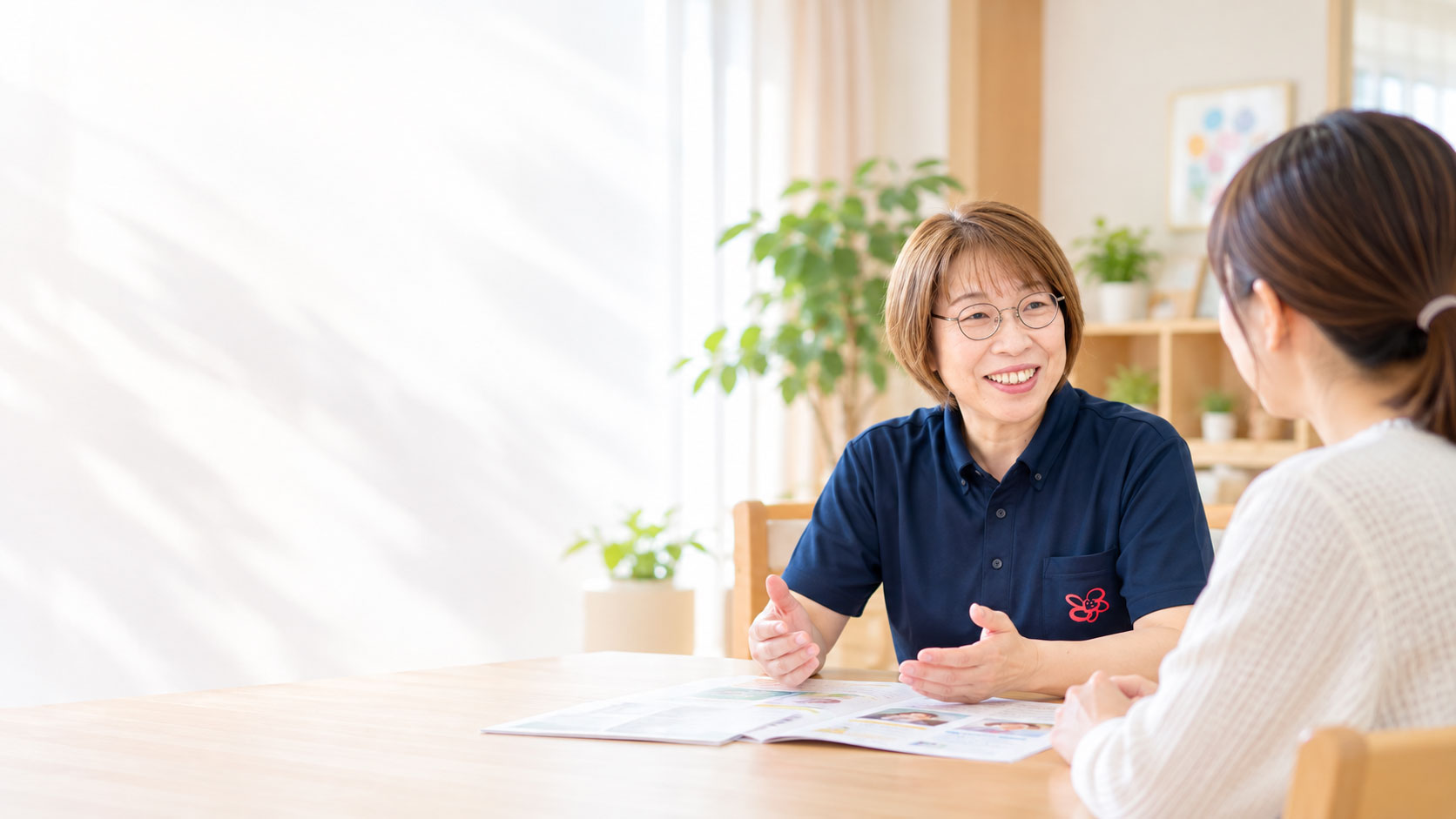 スタッフが保護者の方とテーブルを囲み、利用について相談している様子